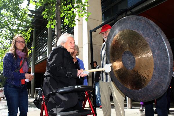 Life-long activist Dorli Rainey, 91,  above, takes her turn sounding the gong in front of Seattle City Hall June 12. Photo by Jon Williams