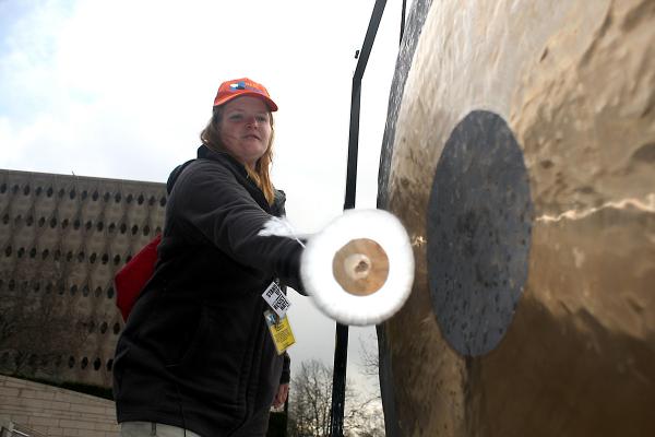 Vendor Lisa Sawyer bangs a gong to raise awareness of homelessness at City Hall in January 2017. Photo by Jon Williams