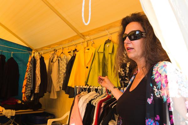 Mary Diederichs runs the donations tent at Camp Second Chance. Diederichs knows campers’ sizes and finds clothing for them. Photo by Matthew S. Browning