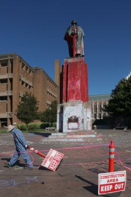 A worker from UW’s Facilities department takes down a barrier that surrounded the statue, which was doused with red paint to symbolize blood. Photo by Jon Williams