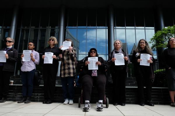 (May 2018 file photo) Members of Women in Black hold a vigil at the Seattle Municipal Court in honor of  the now 42 homeless people who have died outside this year. Photo by Alex Bergstrom