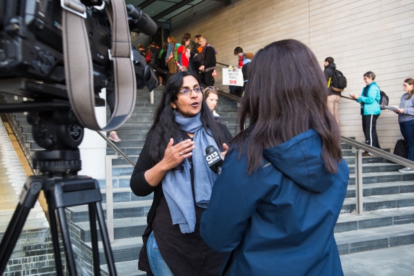 Councilmember Kshama Sawant speaks to a television news reporter on the steps of Seattle City Hall in 2017.