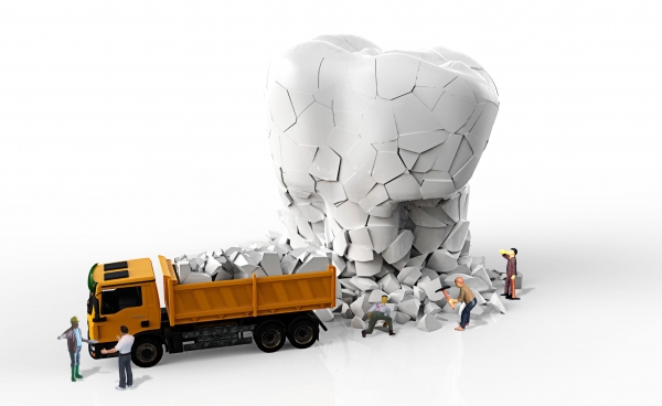 A toy model dump truck unloads pieces of an oversize tooth.