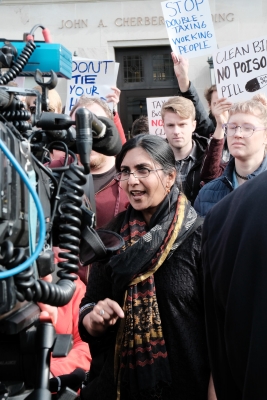 Kshama Sawant stands in front of group of young supporters carrying signs
