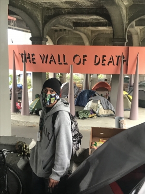 As the REACH neighborhood care coordinator, David Delgado works directly with unhoused people in the Seattle area, such as the community camping under the University Bridge near the permanent art installation “The Wall of Death,” to try to connect them wi