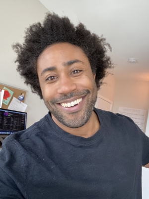 Young Black man wearing Afro and blue sweater
