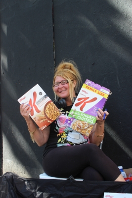 Smiling middle-aged woman with blonde updo and glasses holds boxes of Special K cereal