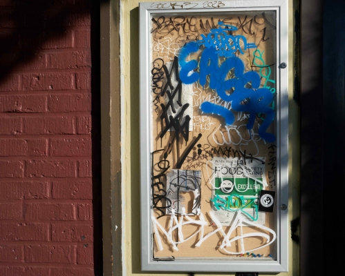 A glass panel is covered in graffiti, including a blue "Eager" scrawl.