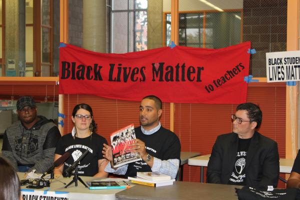 History teacher Jesse Hagopian lifts up culturally relevant curriculum materials at a press conference to announce new initiatives to support Black students at Seattle Public Schools.