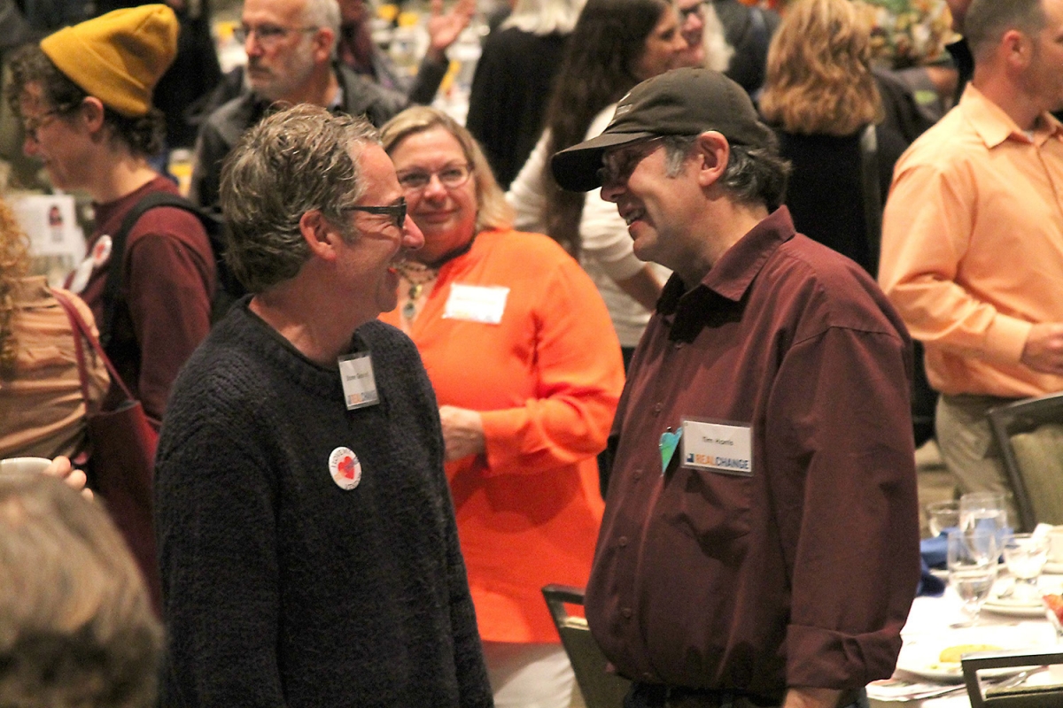 At the 2018 annual breakfast Tim Harris (right) chats with Pearl Jam guitarist Stone Gossard. Photo by Jon Williams