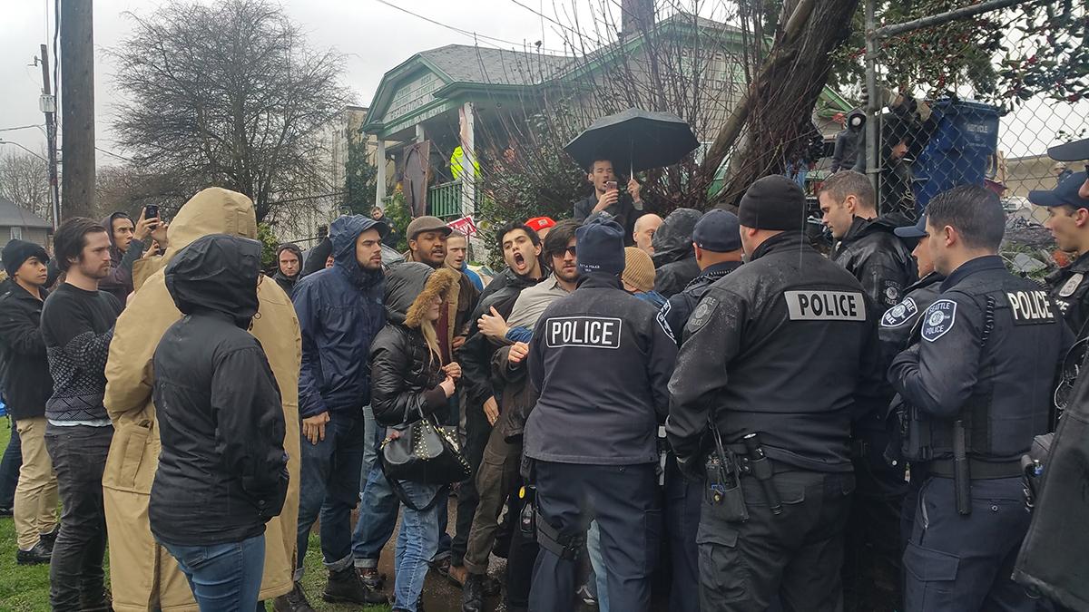 Seattle police clash with protesters outside the Umoja PEACE Center as officers attempt to erect fencing around the property while supporting the King County Sheriff’s Office in the eviction of Omari Tahir-Garrett. Photo by Ashley Archibald