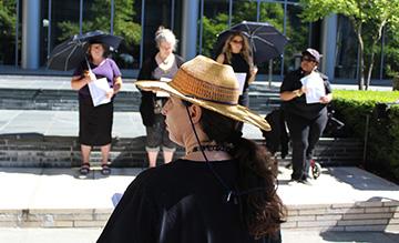 Women in Black participants stood outside of the Seattle Municipal Court in the hot sun Aug. 24 to mourn the deaths of two homeless people killed in Kent in August. Photo by Aaron Burkhalter, Real Change