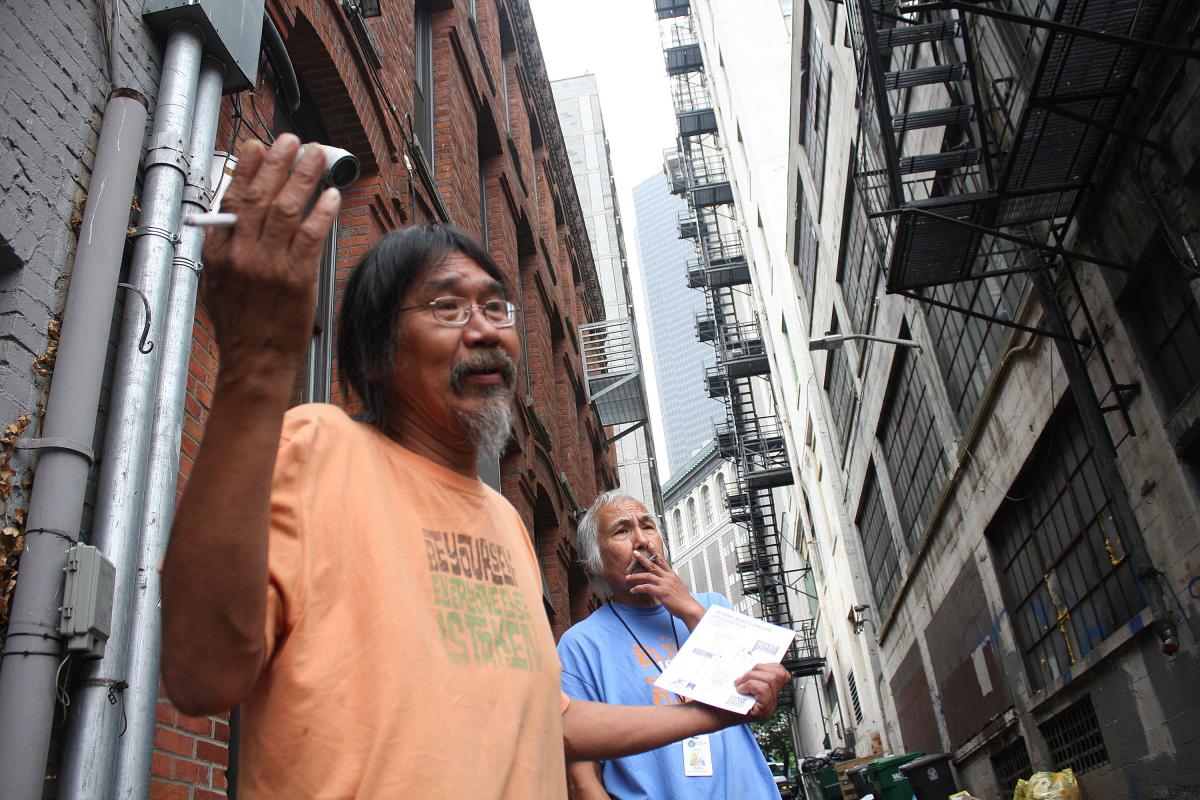 Chief Seattle Club volunteer Matthew Anchorage and a cook, Eddie, talk with artist Suzanne Morlock in the Pioneer Square alley where Morlock's Yellow Brick Road will be displayed