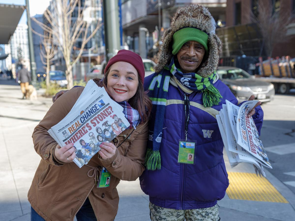 Columnist Hanna Brooks Olsen and vendor Yemane Berhe sell copies of Real Change. Photo by Jeff Few