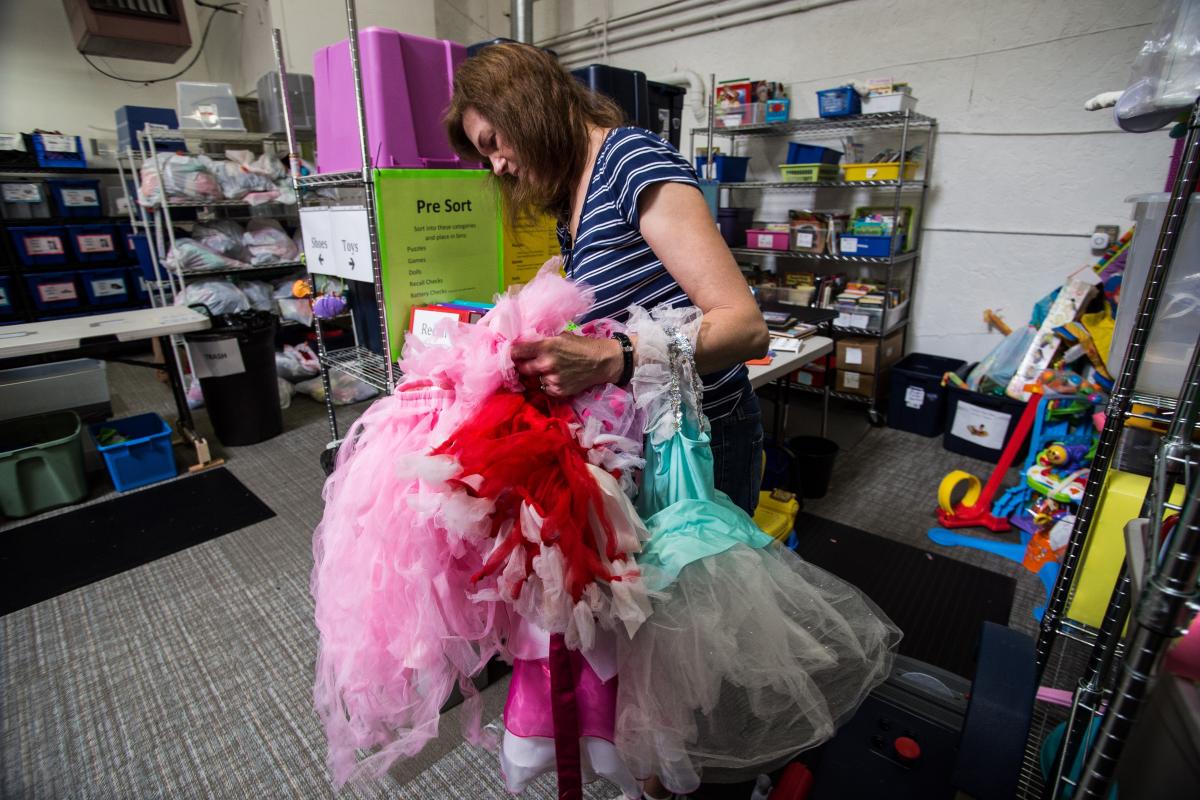 Volunteer Debbie Thoma sorts through donated dresses at Westside Baby in White Center. Photo by Matthew S. Browning.