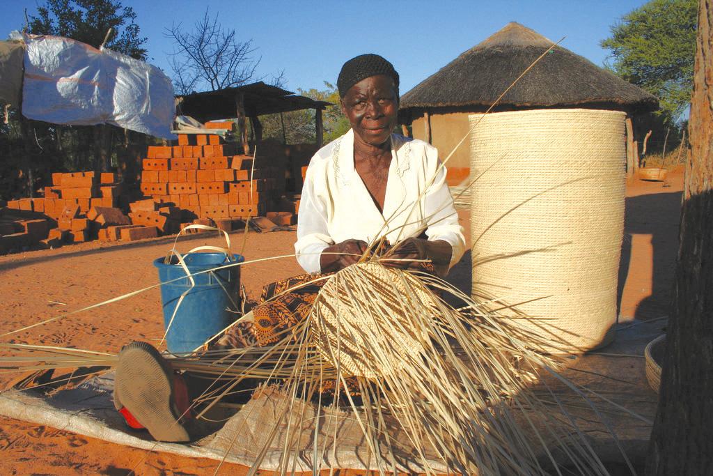 Siduduzile Nyoni completes one of her baskets, which will be sold through a women's cooperative in western Zimbabwe.