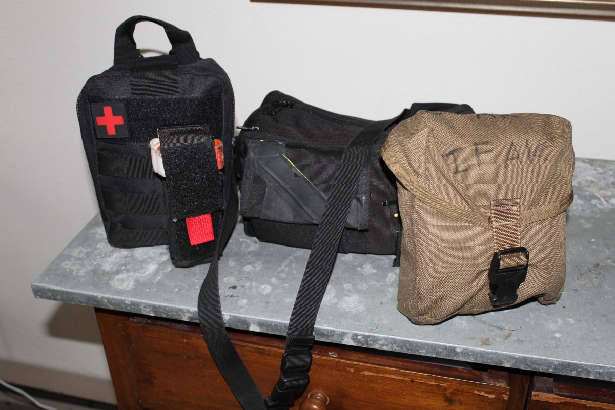 Three individual first aid kits (IFAK) sit on a table.