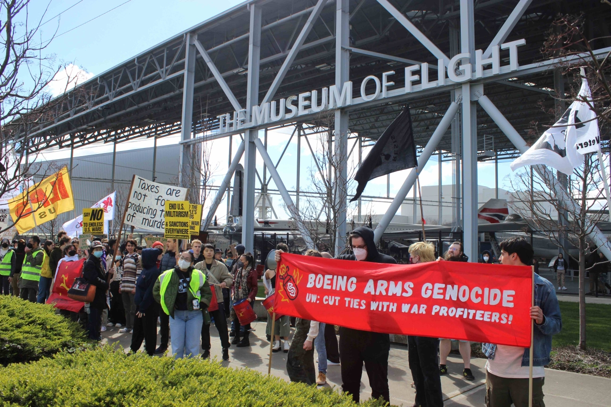 Protestors lined up in front of the Museum of Flight holding signs