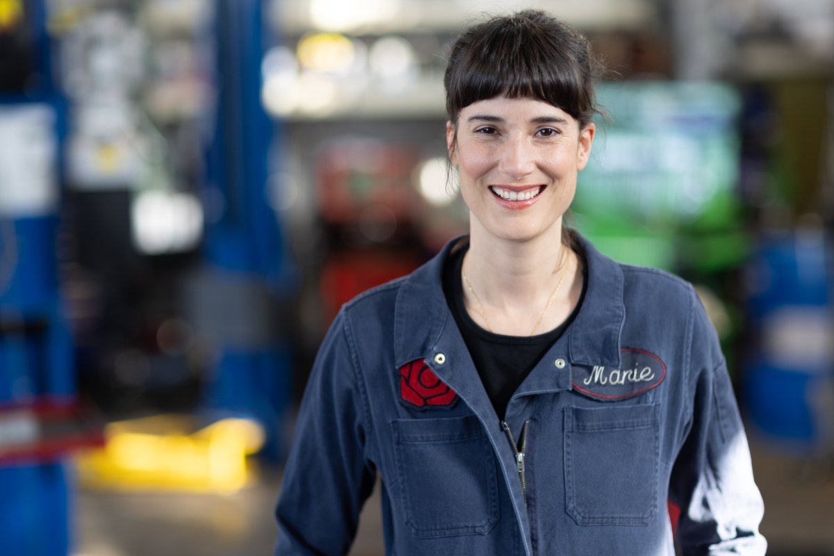 Photograph of a smiling Marie Gluesenkamp Perez in mechanic's jumpsuit