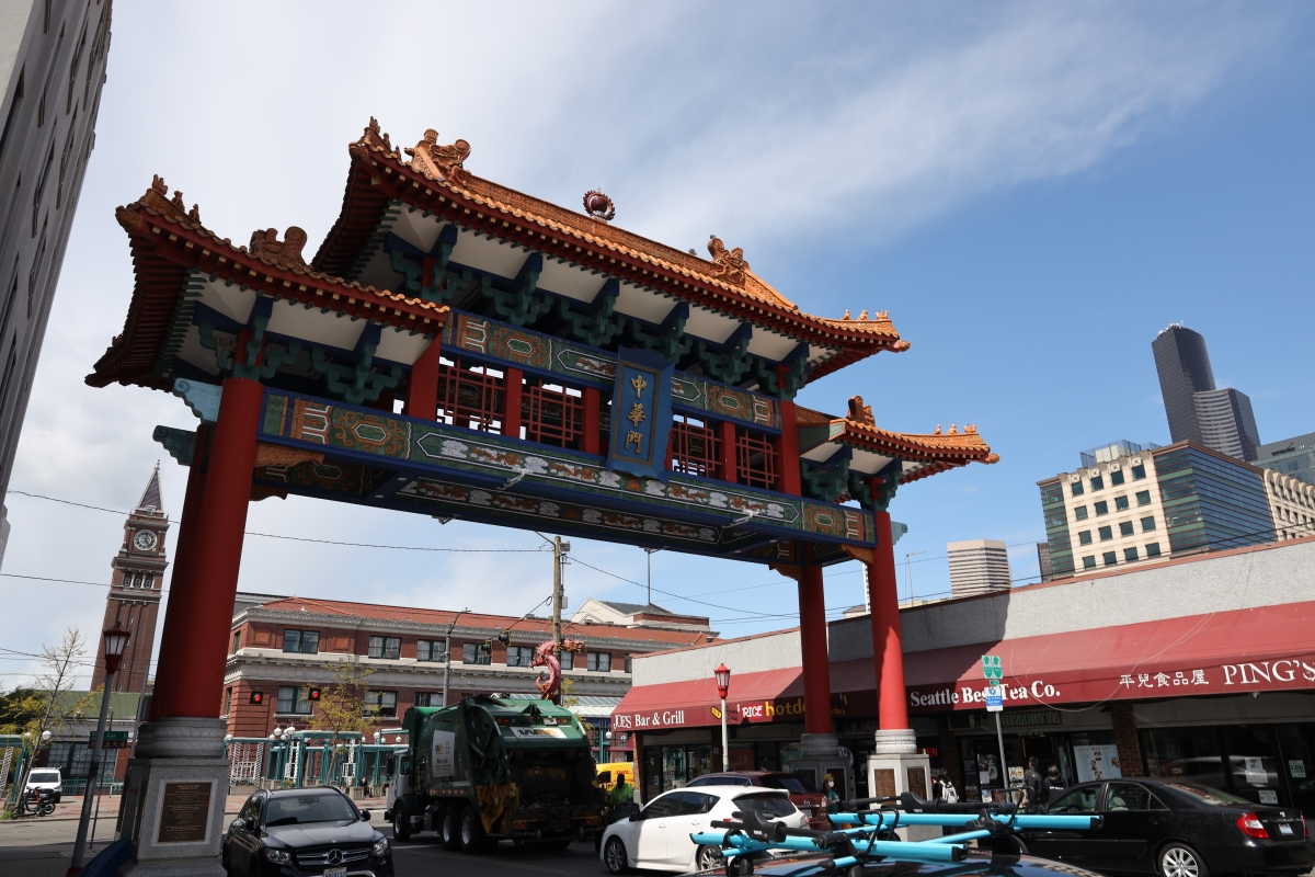 Chinese-style arch towers over downtown buildings with traffic beneath.