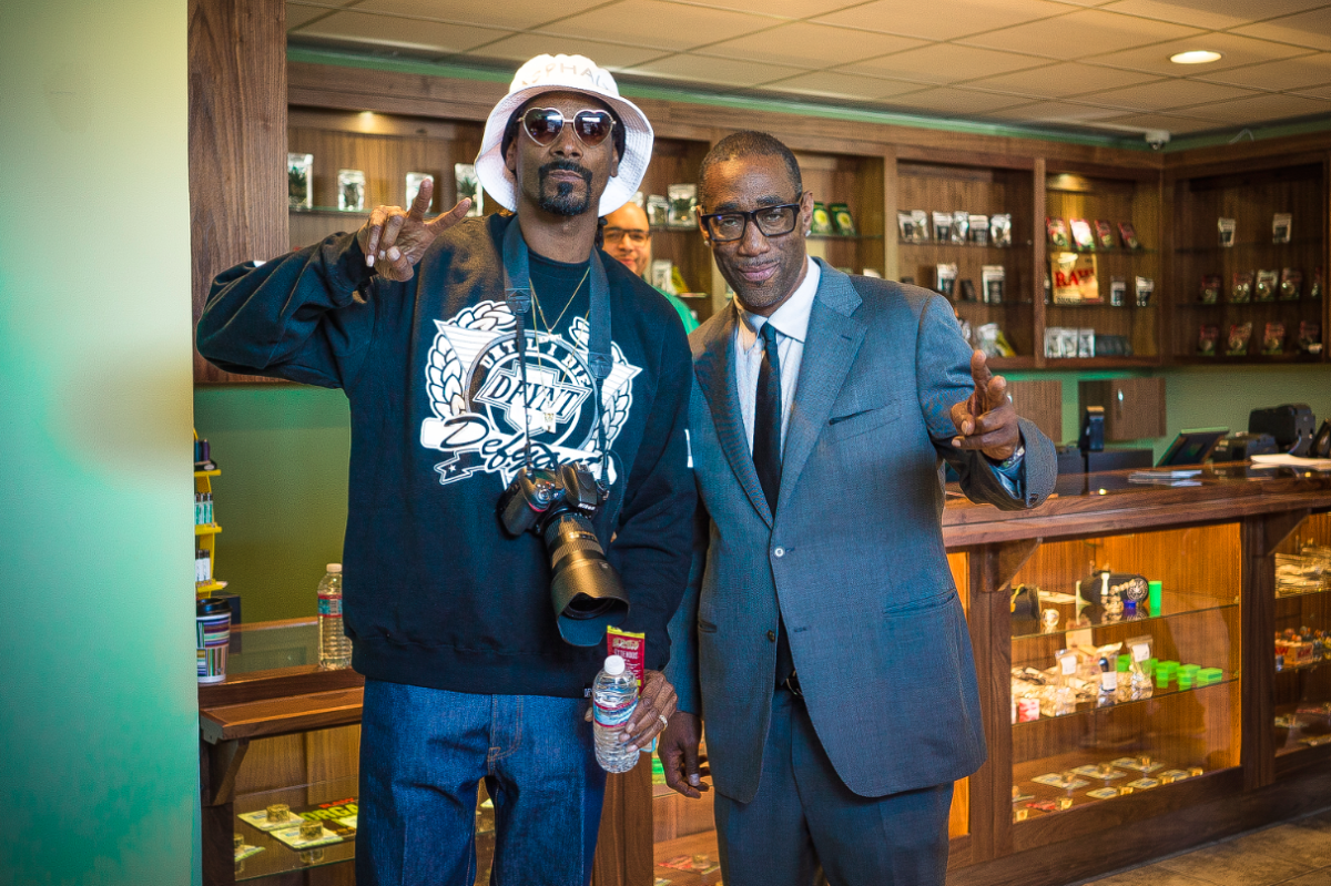 Rapper Snoop Dogg poses with Black man in business suit.