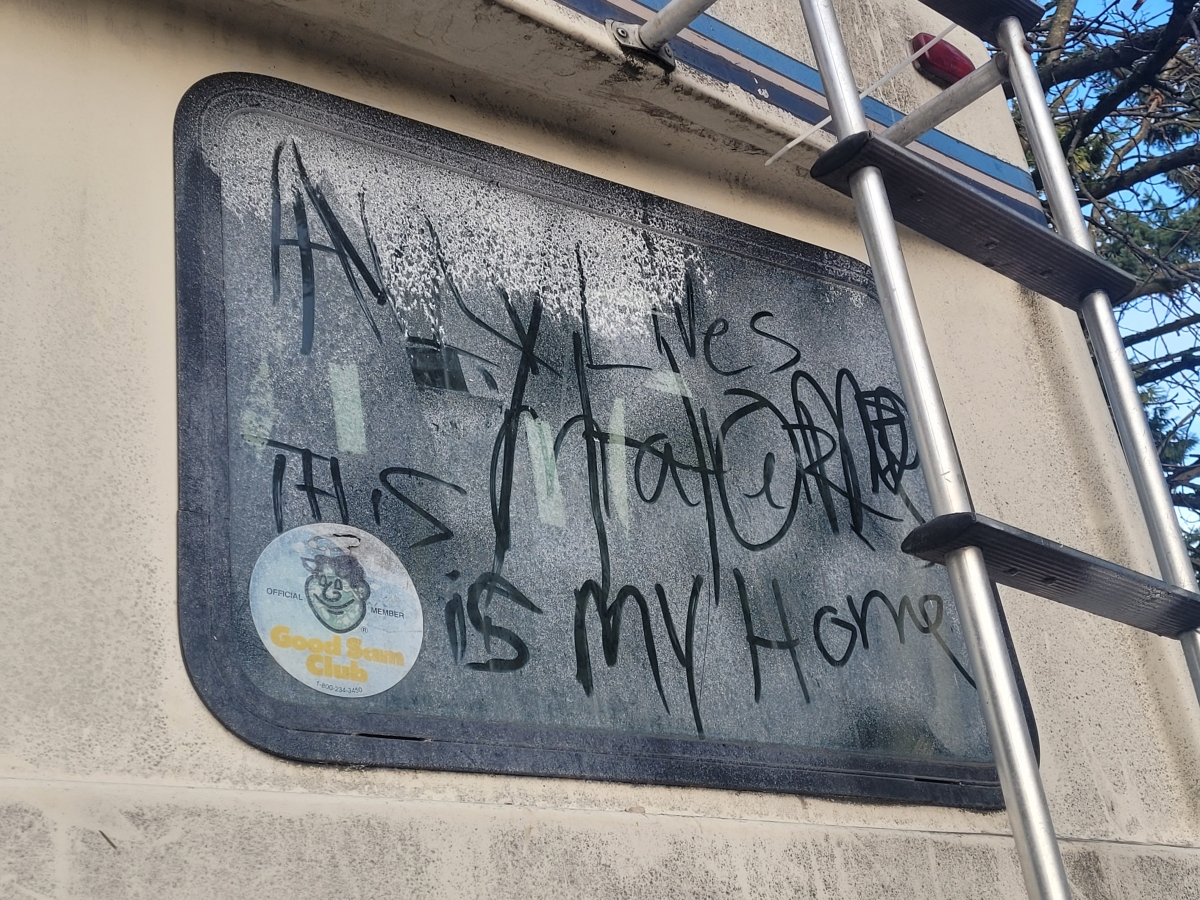 Fogged-up trailer window with writing on it, including phrase "This is my home"