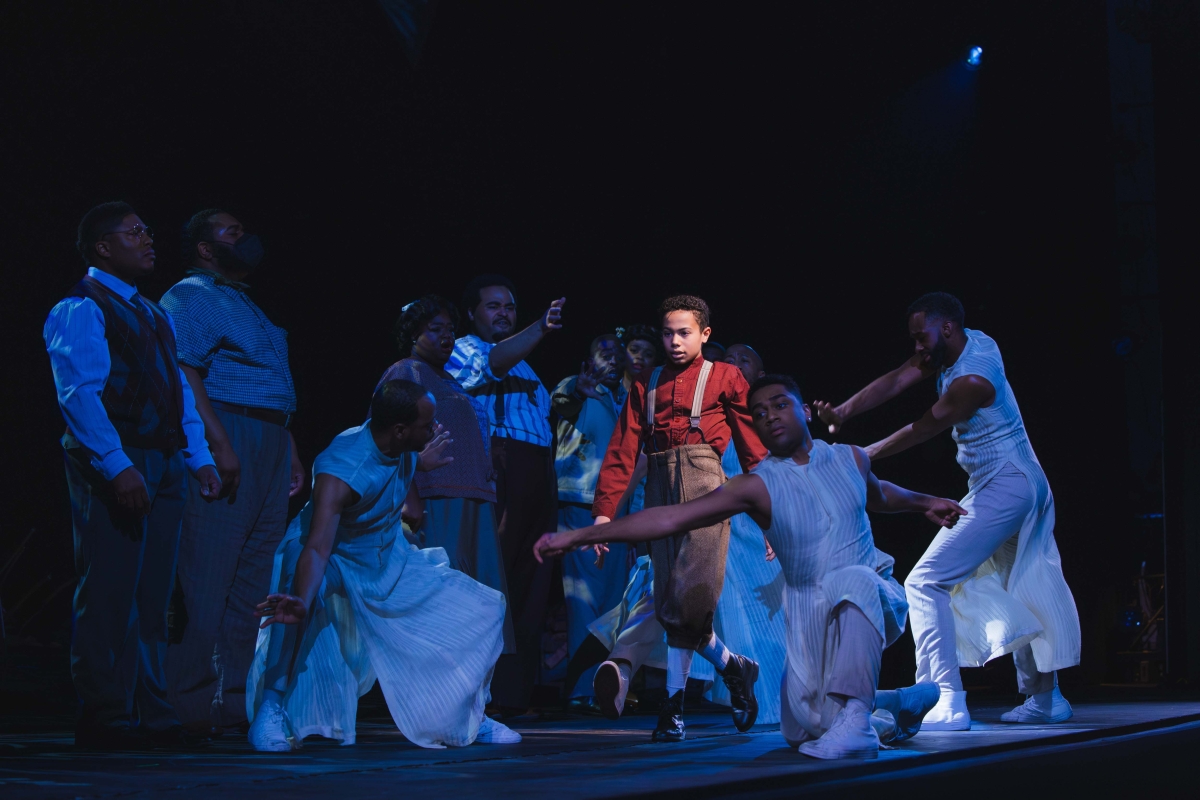A young Black man moves through a group of dancers in "X: The Life and Times of Malcom X" staged by the Seattle Opera at McCaw Hall.