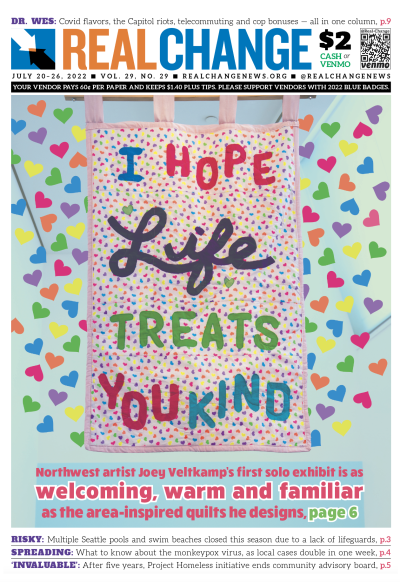 An image of one of artist Joey Veltkamp's quilts, covered in multicolored hearts, that reads "I hope life treats you kind"
