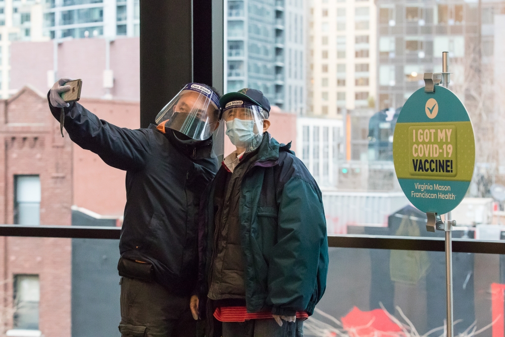 Siu Ping Ng (right) and his son take a celebratory photo at the “Selfie Station” outside the Amazon–Virginia Mason vaccination event.