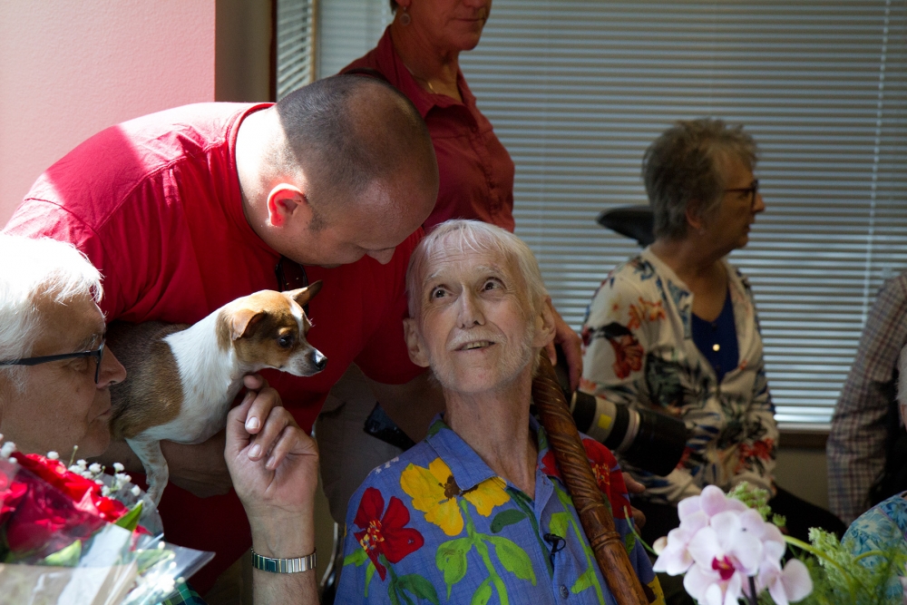 A partygoer leans over to speak to Robert Baxter-Fuller. Photo by Wes Sauer