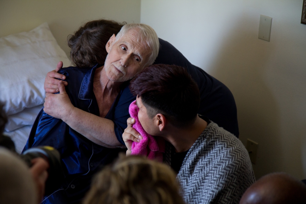 Robert and Reese Baxter-Fuller stare into each other’s’ eyes as people say their last goodbyes to Robert. Photo by Wes Sauer