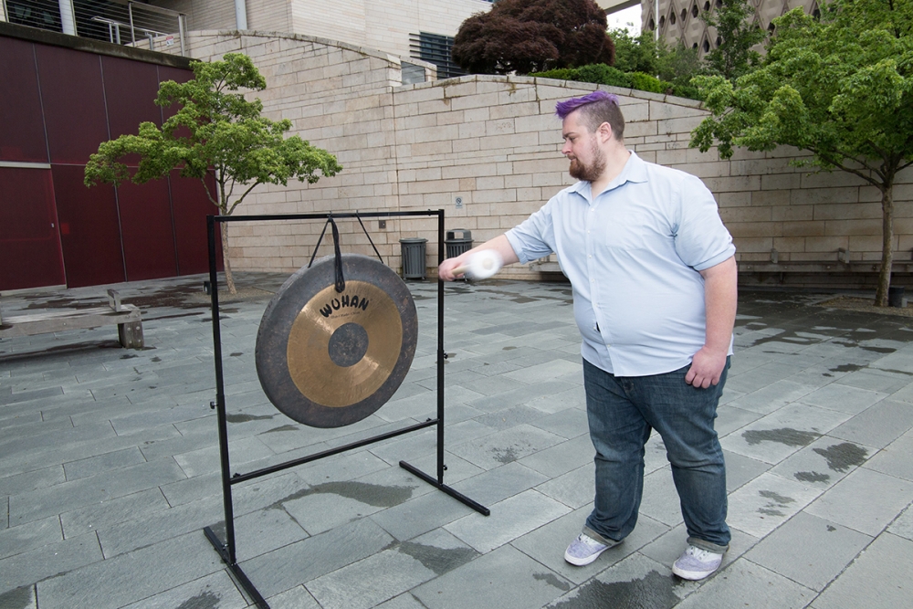 David Corrado from We Count takes a turn in hitting the gong. Photo by Matthew S. Browning