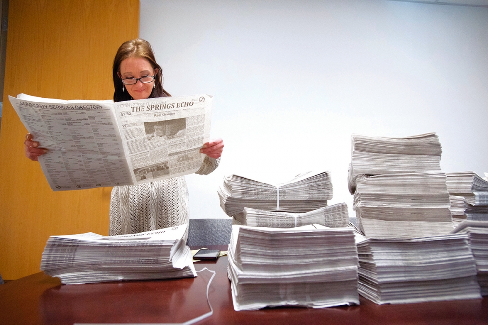 The Springs Echo publisher Raven Canon gets her first look at the first edition of the newspaper Dec. 30 at the offices of Catholic Charities. Photo by Mark Reis, The Gazette
