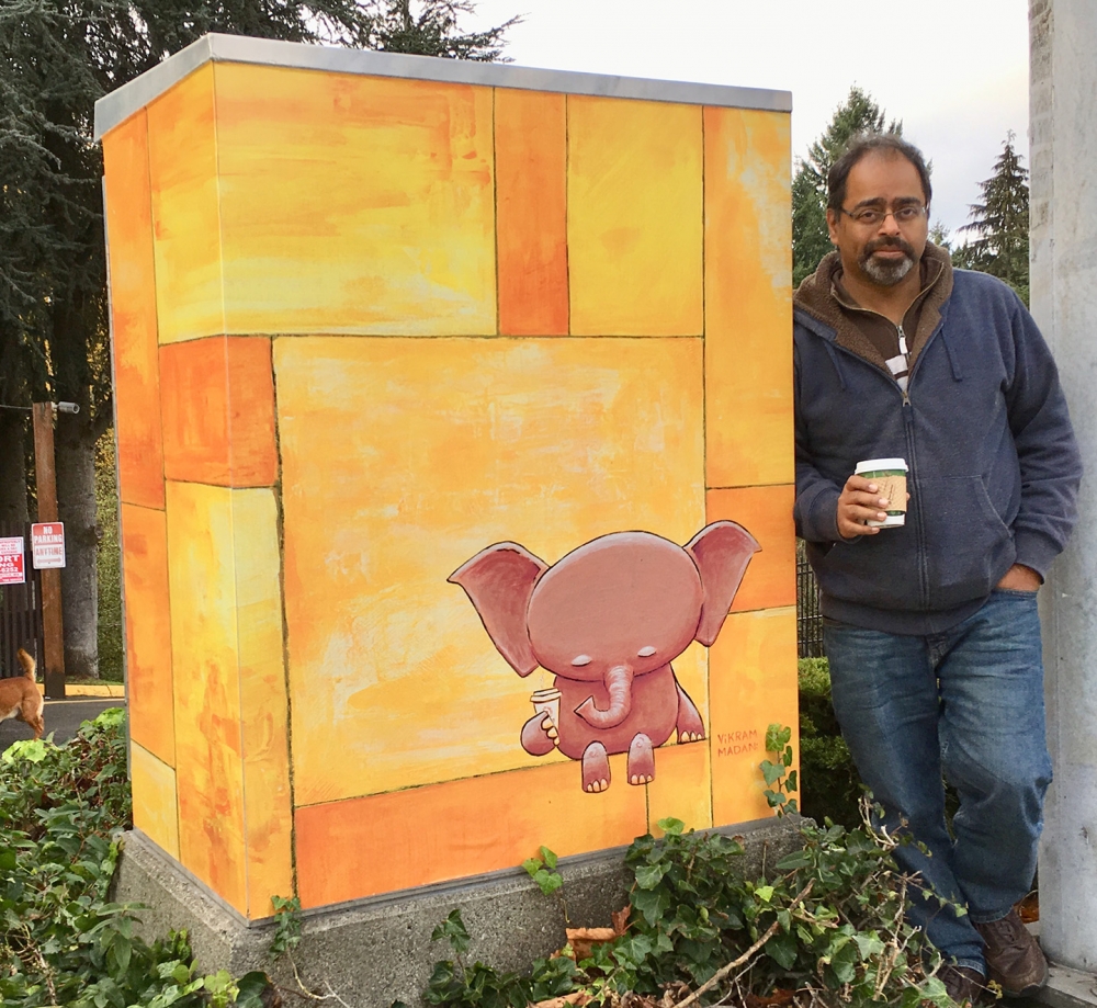 Artist Vikram Madan stands next to a utility box wrap based on 'Contemplation, In Yellow' at the intersection of 122nd and Ambaum in Burien. Photo courtesy Madan.