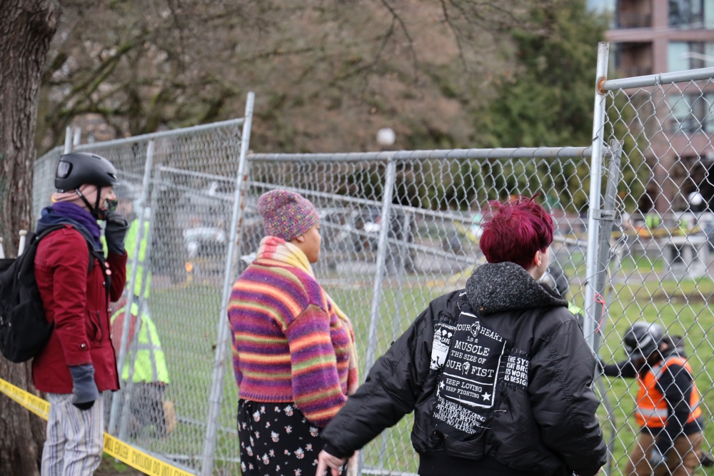 People watch as Seattle city workers demolish the Black Lives Memorial Garden, Dec. 27, 2023.