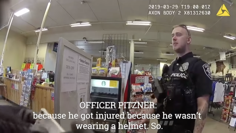 Video still image of young white police officer standing in a convenience store.