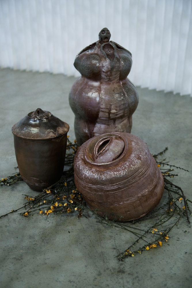Three squat, brown, highly polished pot-like sculptures clustered together